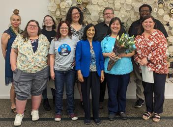 A group of Oak Park Public Library staff pose with a Triton College instructor in front of artwork at the Main Library