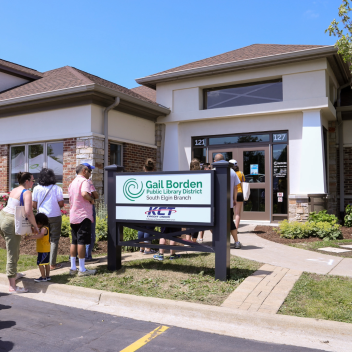The outside of the South Elgin Branch with people lined up to see the new space inside. 