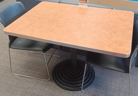 Image of rectangular table with orange top and pedestal base